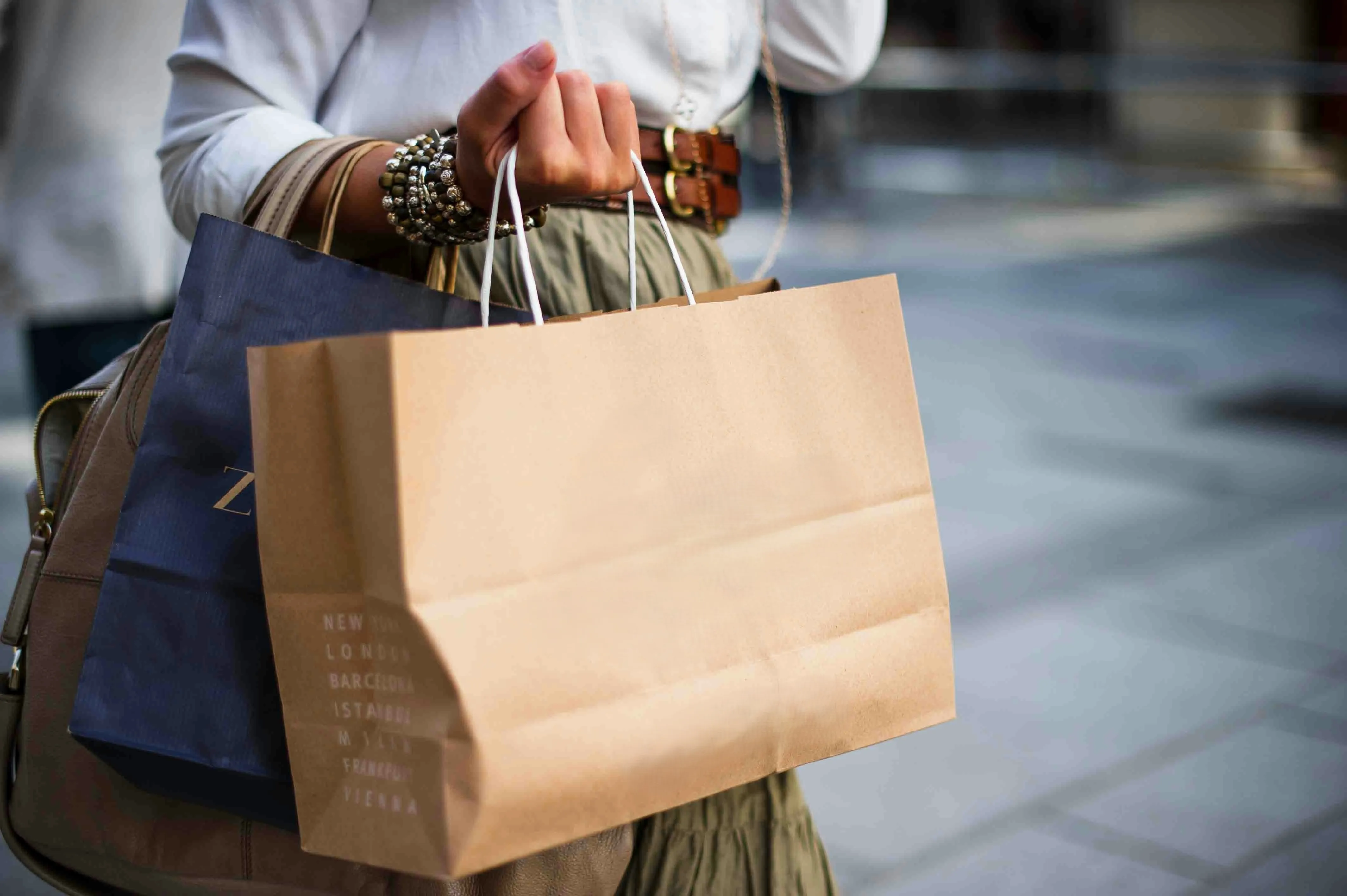 Kundin trägt bunte Einkaufstüten – Sinnbild für den Customer Lifecycle